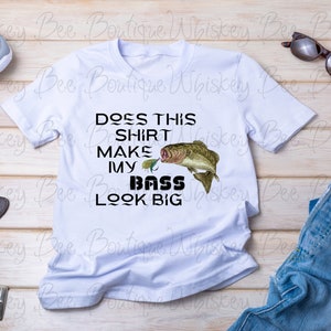 Pode incluir: Camiseta branca com um gráfico preto que diz "Does this shirt make my bass look big?" com uma ilustração de peixe de baixo de desenho animado.