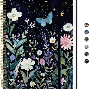 May include: A spiral-bound notebook with a floral and butterfly design. The cover features a dark blue background with white flowers, a blue butterfly, and a starry night sky. The notebook has a gold spiral binding and a black elastic closure.