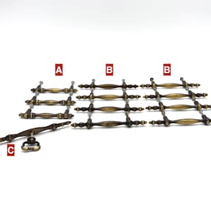 May include: A collection of antique brass-toned metal cabinet hardware, including three drawer pulls labeled A, eight drawer pulls labeled B, and one drop-style handle labeled C. Each piece features a decorative, elongated spindle design.