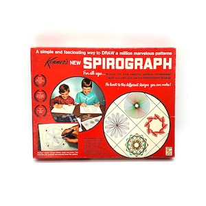 May include: A red rectangular box for Kenner's New Spirograph drawing toy. The front features white text, illustrations of children using the set, and four circular geometric patterns. It includes a list of contents and descriptive product text.