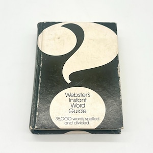 May include: A vintage copy of Webster's Instant Word Guide. The book has a dark cover with a large white question mark design. A white circular label displays the title and the number of words included.