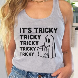 May include: A gray tank top with the text "It's Tricky Tricky Tricky Tricky Tricky" and a black and white illustration of a ghost holding a bag.