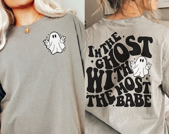 May include: A gray t-shirt with a ghost graphic on the front and the text "I'm the ghost with the most babe" on the back.