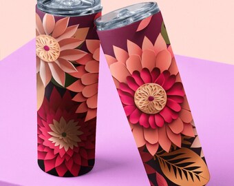 May include: Two stainless steel tumblers featuring a floral design. The tumblers are decorated with paper-like flowers in shades of pink, red, and orange. The background is a dark purple.