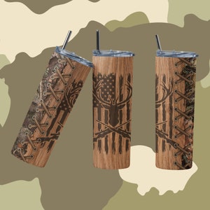 May include: Three stainless steel tumblers with a wood grain finish and a design of a deer head with crossed rifles and an American flag. The tumblers have a camouflage pattern with a brown rope detail.