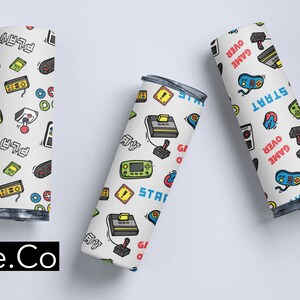 May include: Three white tumblers with a colorful pattern of retro video game controllers, joysticks, and game consoles. The tumblers have the words "Game Over" and "Start" printed on them.