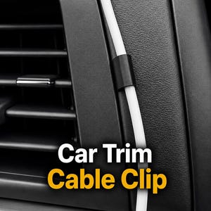 May include: A small black cable clip attached to the textured plastic trim of a vehicle interior, securing a thin white cable that runs vertically along the dashboard surface. The text Car Trim Cable Clip is displayed in white and yellow font.