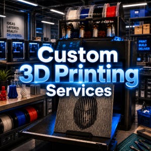 May include: A black industrial 3D printer with multiple filament spools in white, blue, black, and red. The machine features a digital display and a printed gray panel with a repeating "HA" pattern and a central face graphic. Text reads "Custom 3D Printing Services".