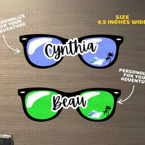 Puede incluir: Dos imanes con forma de gafas de sol, 16,5 cm de ancho, con monturas negras y lentes de colores. El par superior tiene lentes azules con el nombre Cynthia y un crucero. El par inferior tiene lentes verdes con el nombre Beau y un crucero.