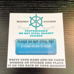 May include: A white magnet sticker with a blue ship's wheel design and text. The text reads "Customizable Do Not Steal Magnet Sticker" and "Please Do Not Steal Me! If Found Return to Cabin:" Instructions are included to write a name or cabin number.