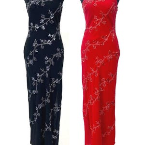 Peut inclure: Deux robes de soirée longues sur mannequins. L'une est noire, l'autre rouge. Les deux ont une conception à une épaule et sont ornées de broderies florales argentées. Idéales pour les événements formels.