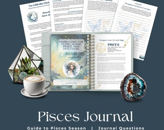 Op de afbeelding: Een dagboek met een blauwe kaft en een gouden spiraalbinding. De kaft heeft een illustratie van een vrouw met lang haar en een bloemenkroon. De titel van het dagboek is "Embracing the Flow: Inner Peace and Intuition" en de ondertitel is "Pisces Season Handbook". Het dagboek is open op een pagina met de titel "Deeper Look At Each Sign" en de tekst "Pisces".