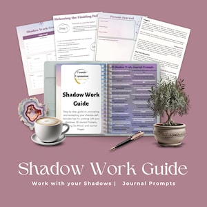 May include: A purple and white guidebook titled "Shadow Work Guide" with the subtitle "Work with your Shadows | Journal Prompts". The guidebook is open to reveal pages with journal prompts and tips for shadow work. The guidebook is surrounded by a cup of coffee, a pen, and a potted plant.