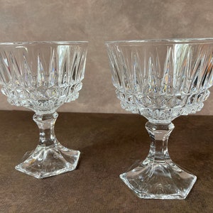 May include: Two clear glass goblets with a diamond-shaped pattern on the bowl and a hexagonal base.