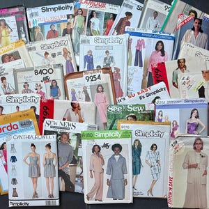 May include: A collection of assorted vintage sewing patterns from brands including Simplicity, Burda, and McCall's. Each paper envelope features printed illustrations of clothing designs, model photographs, brand logos, and various numerical pattern codes.
