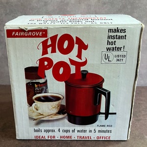 May include: A red electric hot pot with a black handle and a black base. The box says "Fairgrove Hot Pot" and "makes instant hot water!" The box also says "boils approx. 4 cups of water in 5 minutes" and "Ideal for home, travel, office".