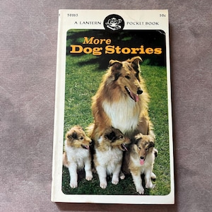 May include: A vintage paperback book titled "More Dog Stories." The cover features a collie with three puppies on a green lawn. The book is a Lantern Pocket Book, with the price of 50¢.