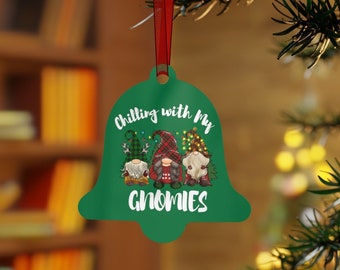 May include: Green bell-shaped Christmas bauble with the text "Chilling with my Gnomies" and three gnomes wearing red and green plaid hats.