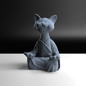 Op de afbeelding: Een grijs keramiek kattenbeeldje dat in meditatieve houding zit met zijn ogen gesloten en een serene uitdrukking. De kat draagt ​​een robenachtig kledingstuk en heeft een rond, cartoonachtig uiterlijk.
