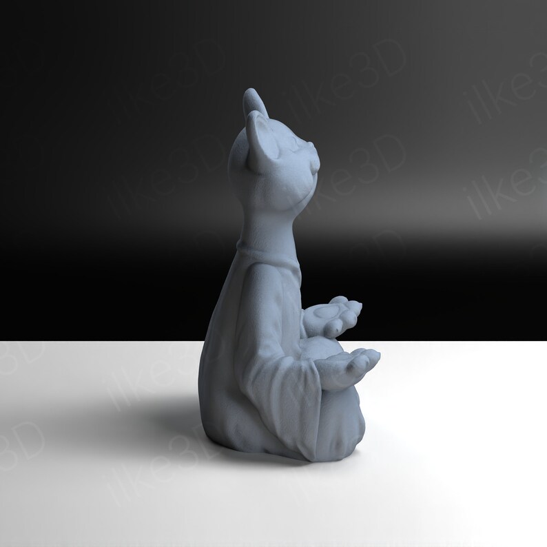 Op de afbeelding: Een grijs keramiek beeldje van een kat die in meditatieve houding zit met zijn ogen dicht. De kat draagt een gewaad en heeft zijn poten gevouwen op zijn schoot.