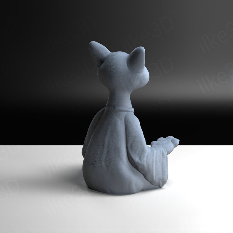 Op de afbeelding: Een grijs keramiek beeldje van een kat die in meditatieve houding zit met zijn ogen dicht. De kat draagt een gewaad en heeft een vredige uitdrukking.