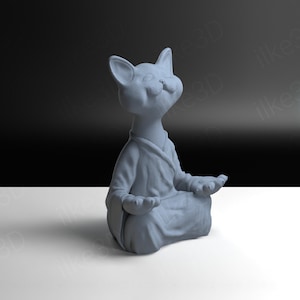Op de afbeelding: Een grijs keramiek beeldje van een kat die in meditatieve houding zit met zijn ogen dicht. De kat draagt een gewaad en heeft een serene uitdrukking op zijn gezicht.