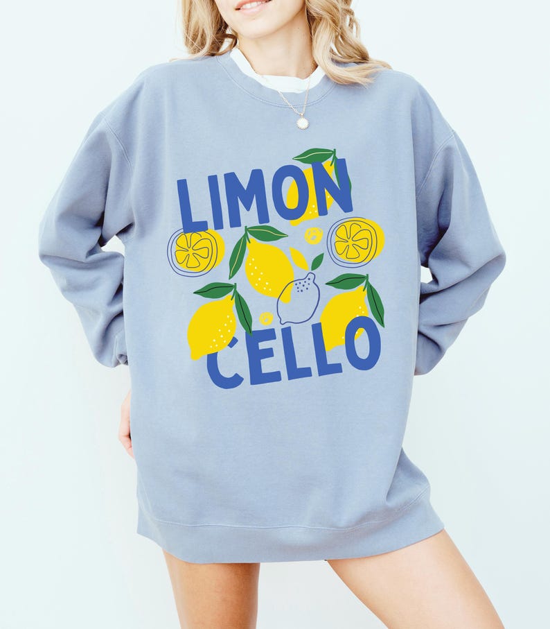 May include: A light blue sweatshirt with a graphic design of lemons and the text "LIMONCELLO" in blue.