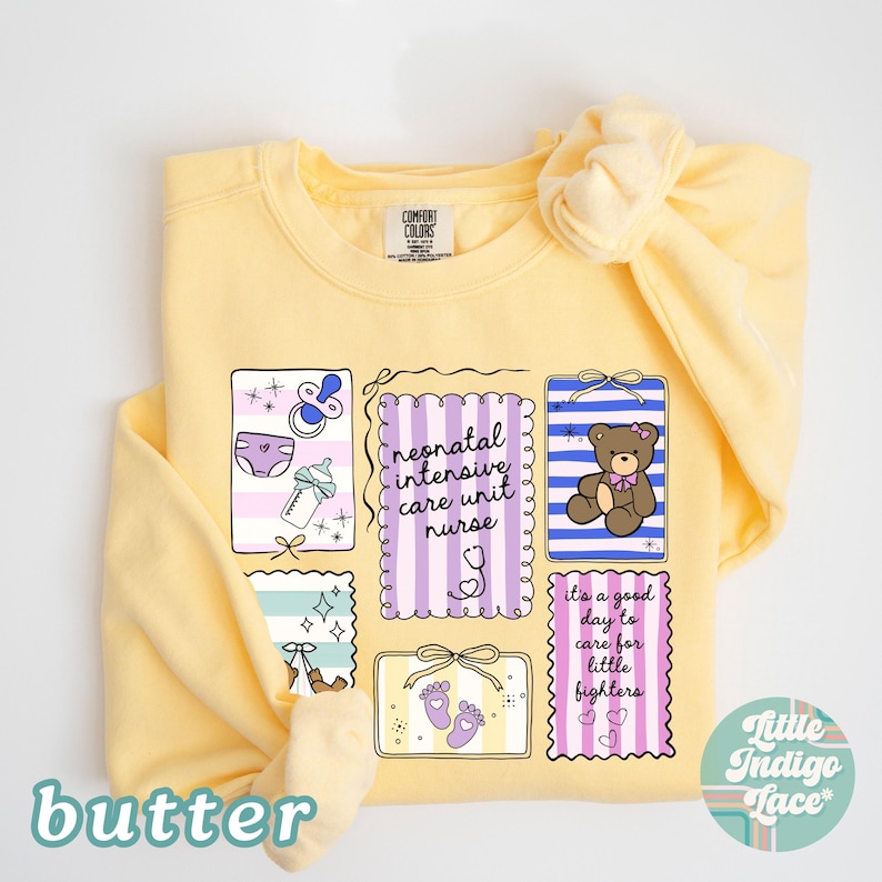 Puede incluir: Una sudadera amarilla clara con un dise&ntilde;o gr&aacute;fico que presenta ilustraciones relacionadas con beb&eacute;s y texto. El dise&ntilde;o incluye un chupete, un pa&ntilde;al, un biber&oacute;n, un osito de peluche y las palabras "neonatal intensive care unit nurse" y "it's a good day to care for little fighters."