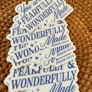 May include: A stack of white stickers with blue text that reads "You are fearfully and wonderfully made" and "Psalm 139:14".