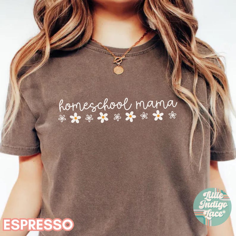 May include: A brown t-shirt with the text "homeschool mama" in white lettering. A row of white daisies are below the text.