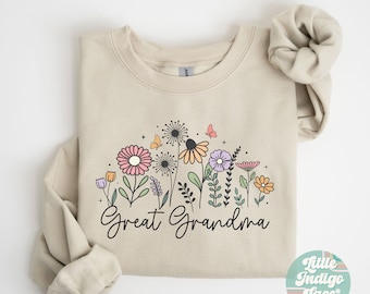 May include: A beige sweatshirt with a floral design and the text "Great Grandma" printed on the front. The sweatshirt is folded in half and the sleeves are rolled up.