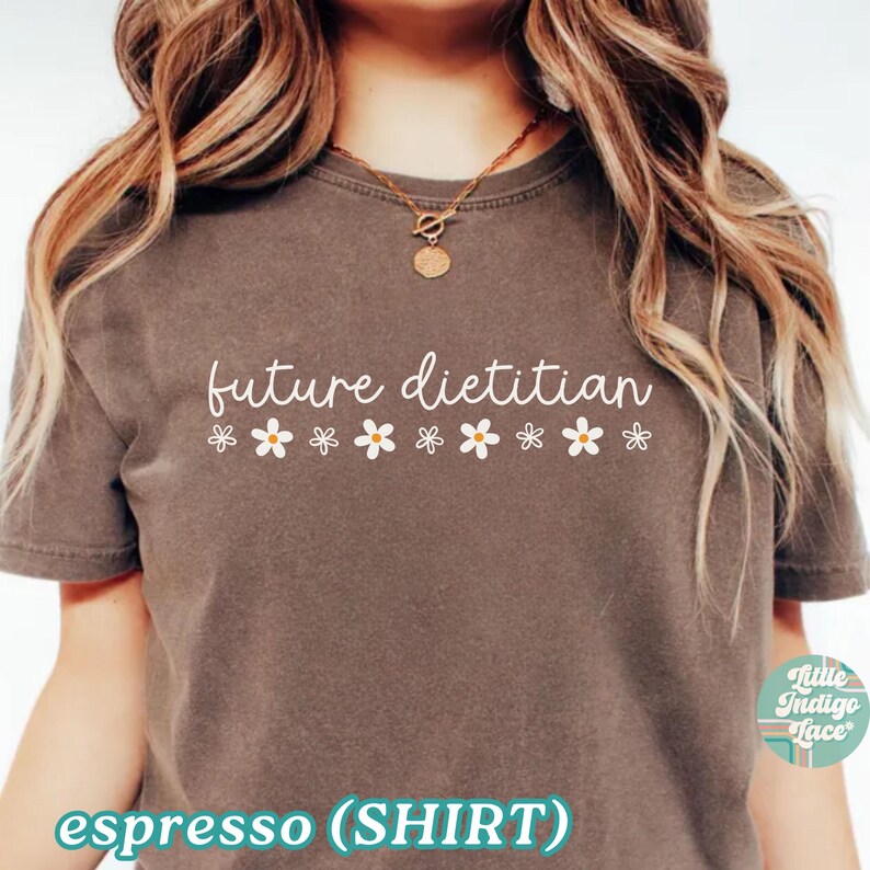 May include: Espresso-colored t-shirt with the text "future dietitian" in white script, adorned with small daisy graphics. The shirt has a crew neck and short sleeves. The words "espresso (SHIRT)" are at the bottom.