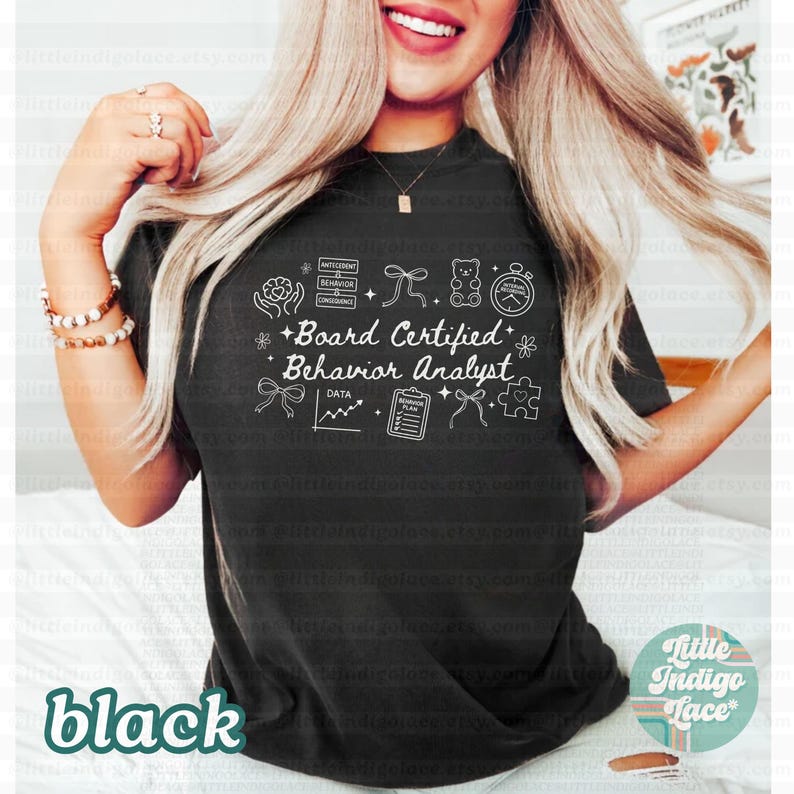 May include: Black t-shirt with the text "Board Certified Behavior Analyst" in white, along with related icons. The word "black" is printed in a lower corner. The shirt is a crew neck.