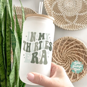 May include: A white tumbler with a bamboo lid and a green and white graphic that says "In My Thirties Era".