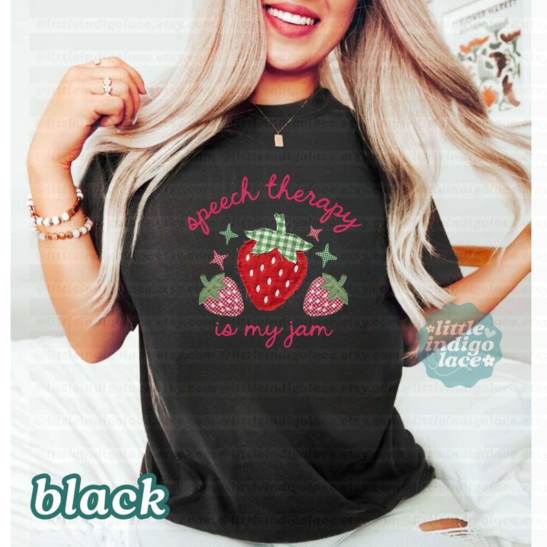 K&ouml;nnte beinhalten: Schwarzes T-Shirt mit dem Text "speech therapy is my jam" in rosa Schrift. Das Design zeigt eine gro&szlig;e rote Erdbeere mit einem gr&uuml;n karierten Oberteil und zwei kleineren Erdbeeren. Das Wort "black" steht unten.