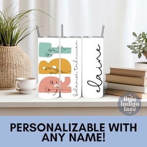 May include: Three stainless steel tumblers with a floral design and the text "Behavior Technician" and "elaine". The tumblers are on a white shelf with a stack of books and a plant in a woven basket.