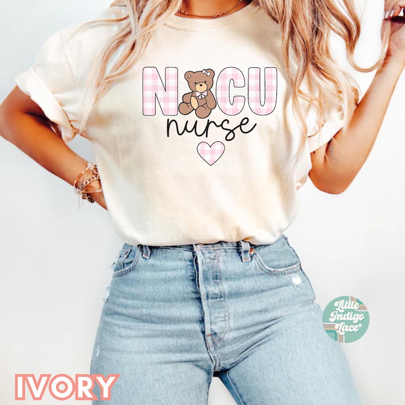 Puede incluir: Una camiseta blanca con un dise&ntilde;o a cuadros rosa y blanco que dice "NICU nurse" con un gr&aacute;fico de oso de peluche rosa y un coraz&oacute;n rosa.