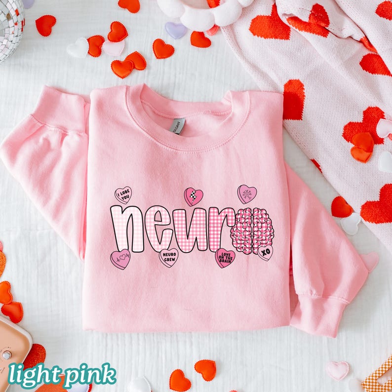 May include: Light pink sweatshirt with the word "neuro" in a checkered pattern and a brain graphic. The sweatshirt has several heart-shaped graphics with phrases like "I love you" and "love on the brain".