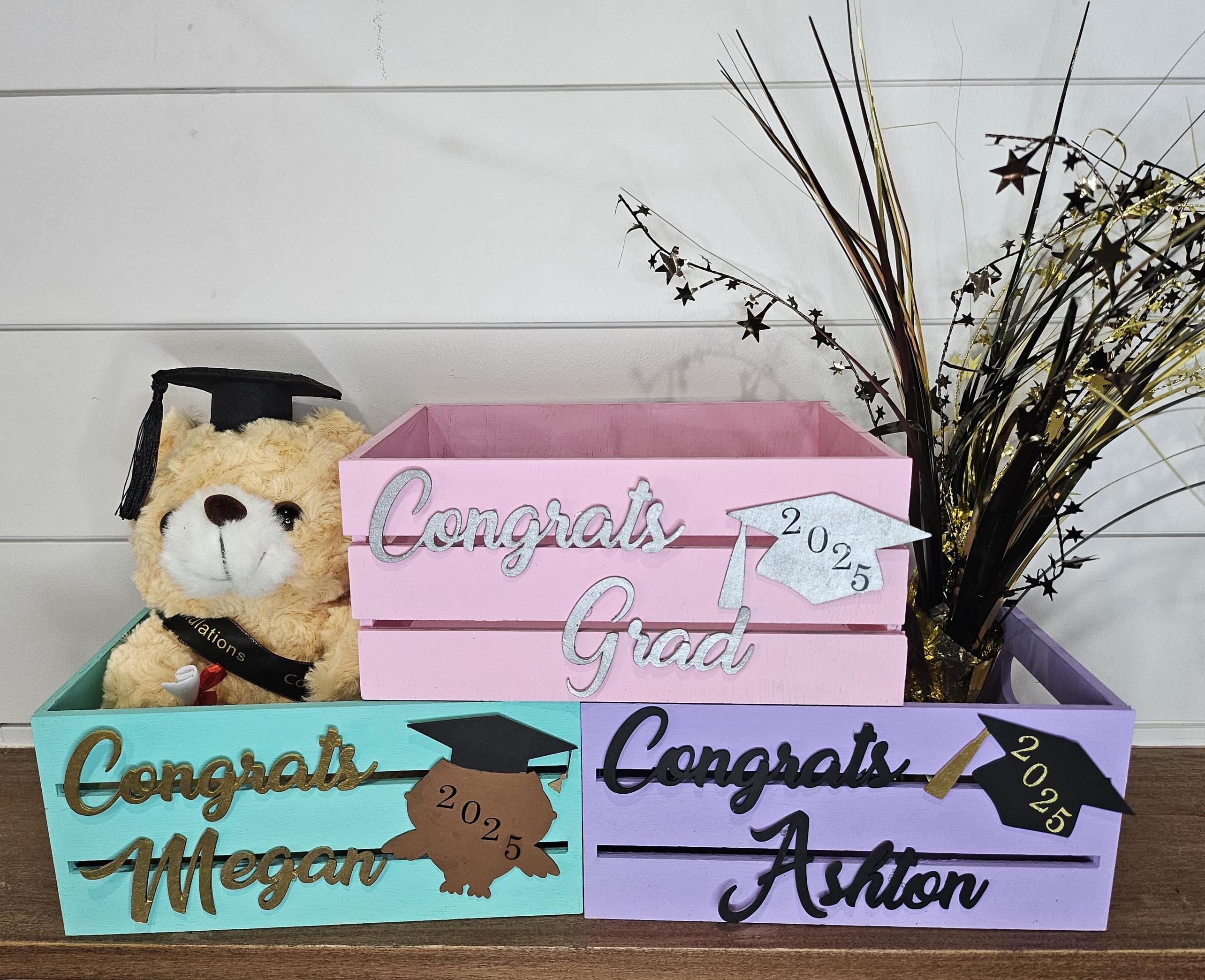 Three personalized wooden graduation crates with name and a grad cap design featuring the graduation year. Perfect for holding gifts, cards, or as decor at graduation parties.