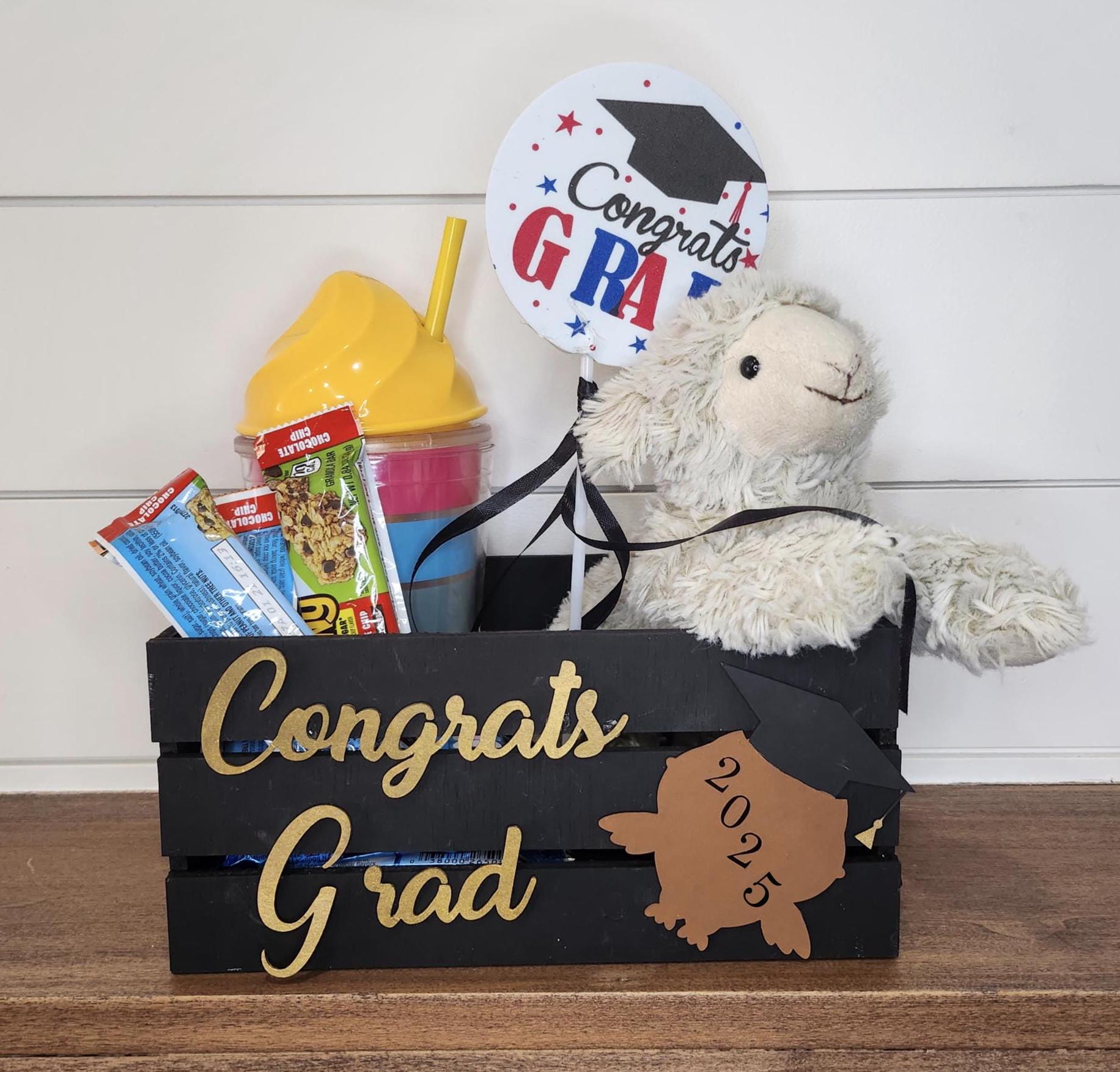 Custom black wooden graduation crate with a gold name and a grad owl design featuring the graduation year. Perfect for holding gifts, cards, or as decor at graduation parties.