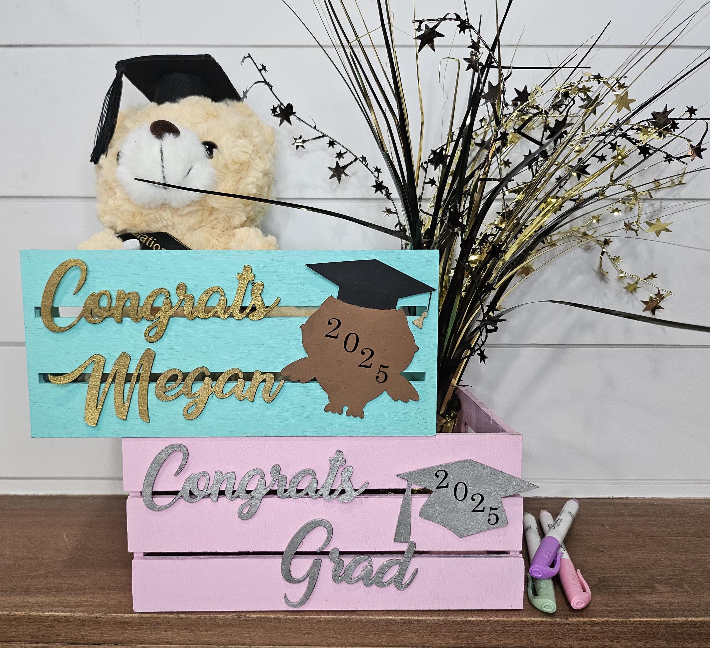 Two personalized wooden graduation crates with name and a grad cap design featuring the graduation year. Perfect for holding gifts, cards, or as decor at graduation parties.
