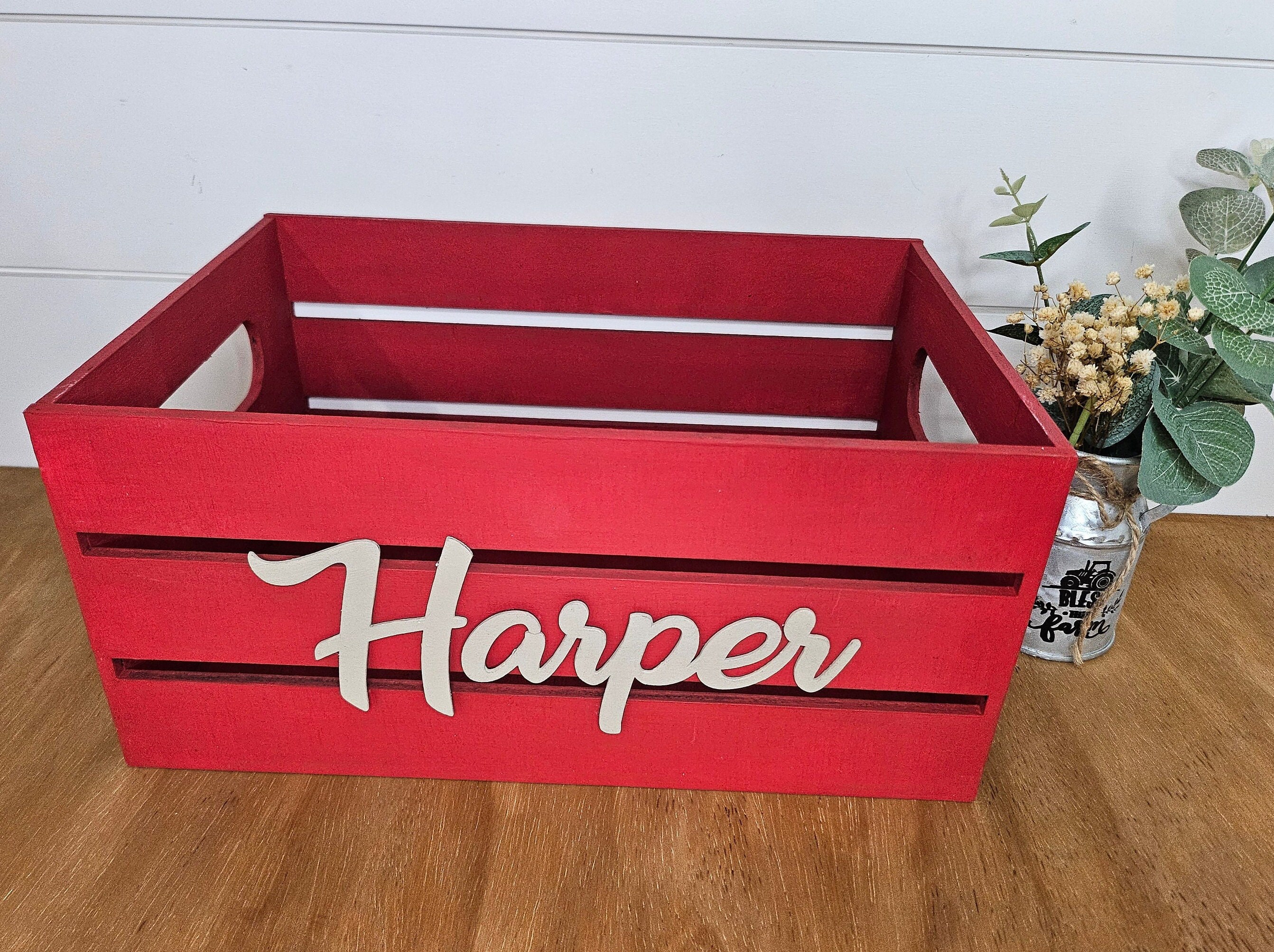 A red wooden crate with beige name . Ideal for organizing or adding a decorative touch to a nursery or kids room.