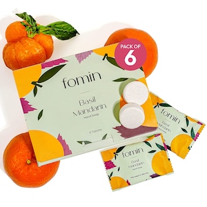 May include: A pack of six hand soap tablets in a green and white box with a mandarin orange design. The box says "fomin Basil Mandarin Hand Soap" and "6 Tablets". There are two individual tablets and two individual packets of soap visible.