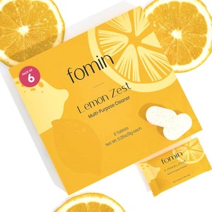 May include: A yellow box with a lemon design and the text "fomin Lemon Zest Multi-Purpose Cleaner" and "PACK OF 6" on the front. The box contains 6 tablets, each weighing 0.28 ounces or 8 grams. There is also a smaller yellow packet with the same design and text.
