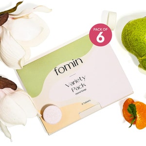 May include: A pack of six fomin variety pack hand soap tablets. The pack is white with green and orange accents. The text "fomin" and "Variety Pack" is printed on the pack. The text "Hand Soap" is printed in smaller font below "Variety Pack". The text "6 Tablets" is printed on the bottom right corner of the pack. The pack is sitting on a white surface.