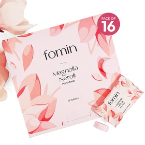 May include: A pack of 16 hand soap tablets in a pink and white box with a floral design. The box says "fomin Magnolia Neroli Hand Soap" and "16 Tablets". The tablets are white and round with a pink floral design.