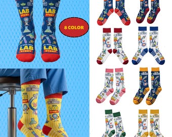 May include: A collection of eight pairs of novelty socks with a science theme. Each pair features the text "DR. MARRY 2026 LAB STORY" and various lab-related graphics. The socks come in a variety of colors, including blue, red, yellow, and green.