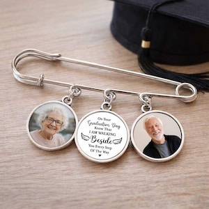 May include: A silver graduation pin with three circular charms. Two charms feature photos of people, and the center charm has the text "On Your Graduation Day Know That I AM WALKING Beside You Every Step Of The Way."