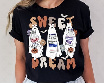 May include: Black t-shirt with a graphic of three ghosts holding vials labeled "Fentanyl", "Propofol", and "Precedex". The text "Sweet Dream" is written in a dripping font below the ghosts.