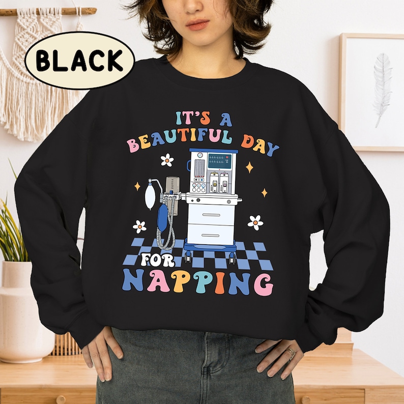 May include: Black sweatshirt with a graphic of a medical ventilator and the text "It's a beautiful day for napping" in rainbow colors.